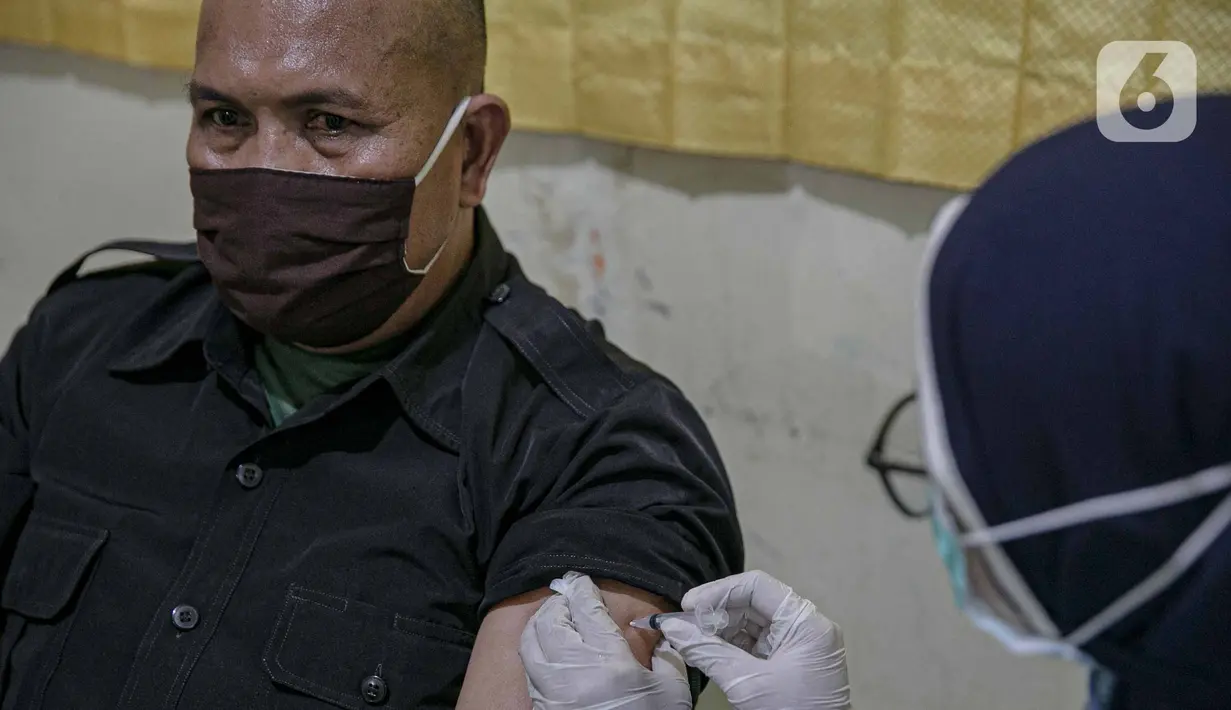 Tenaga kesehatan menyuntikkan vaksin COVID-19 pada tenaga pendidik di SMP 216, Jakarta Pusat, Selasa (6/4/2021). Pemerintah akan mengatur kembali pemberian vaksin Covid-19 kepada masyarakat karena terbatasnya pasokan vaksin saat ini. (Liputan6.com/Faizal Fanani)