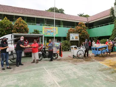 Founder of Foodbank of Indonesia Hendro Utama, Executive Dir. Head of Group Strategic Marcomm PT Bank DBS Indonesia Mona Monika dan Managing Director Head of Digital Banking Leonardo Koesmanto secara simbolis memberikan paket makanan di Cipulir, Jakarta Jumat(18/12/2020). (Liputan6.com/Fery Pradolo)