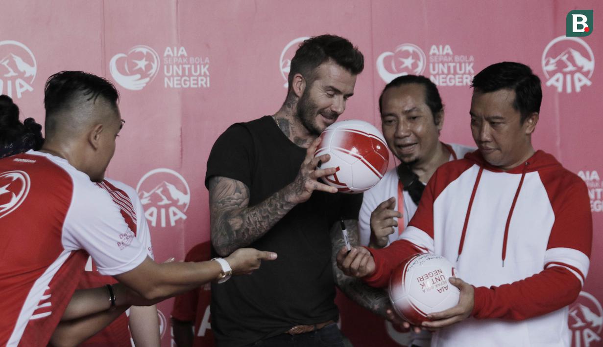 Legenda sepak bola Inggris, David Beckham, dan Menpora RI, Imam Nahrawi, bertukar bola di Stadion Soemantri Brodjonegoro, Jakarta, Minggu (25/3/2018). AIA membagikan 10.000 bola kepada akademi sepak bola di Indonesia. (Bola.com/M Iqbal Ichsan)