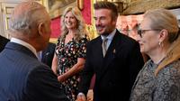 Mantan pemain sepak bola Inggris, David Beckham (tengah), berjabat tangan dengan Raja Inggris Charles III (kiri) selama upacara Penghargaan Yayasan Raja, pada peringatan 35 tahun Yayasan Raja, di Istana St James, London, pada 12 Juni 2025. (Chris J RATCLIFFE/POOL/AFP)