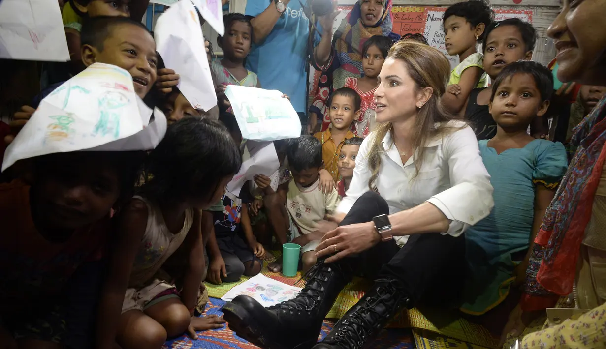 Ratu Yordania Rania berinteraksi dengan anak-anak Rohingya di kamp pengungsi Kutupalong di Ukhia (23/10). Kunjungan tersebut sengaja dilakukan untuk menemui para pengungsi Rohingya di sana yang melarikan diri dari Myanmar. (AFP Photo/Tauseef Mustafa)