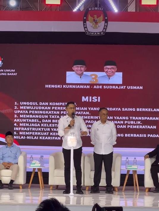 Di nomor urut tiga ada Hengky Kurniawan dan Ade Sudrajat. Keduanya kompak kenakan kemeja putih dan celana hitam. Hengky yang pernah menjabat sebagai Bupati Bandung Barat sisa masa jabatan 2018–2023 ini tampil santai selama debat. Meski sempat ada masalah pada mic dan pertanyaan tiba-tiba dirubah, namun ia tetap semangat dalam menjemput kemenangan. (Liputan6.com/IG/@sonyafatmala)