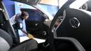 Pekerja membersihkan mobil Datsun Go+ Panca di Diler Nissan kawasan Pulogadung, Jakarta, Rabu (27/11/2019). Pabrik mobil Datsun akan dialihfungsikan untuk memproduksi mesin mobil jenis lain dan lebih fokus mengembangkan kendaraan listrik. (merdeka.com/Iqbal Nugroho)