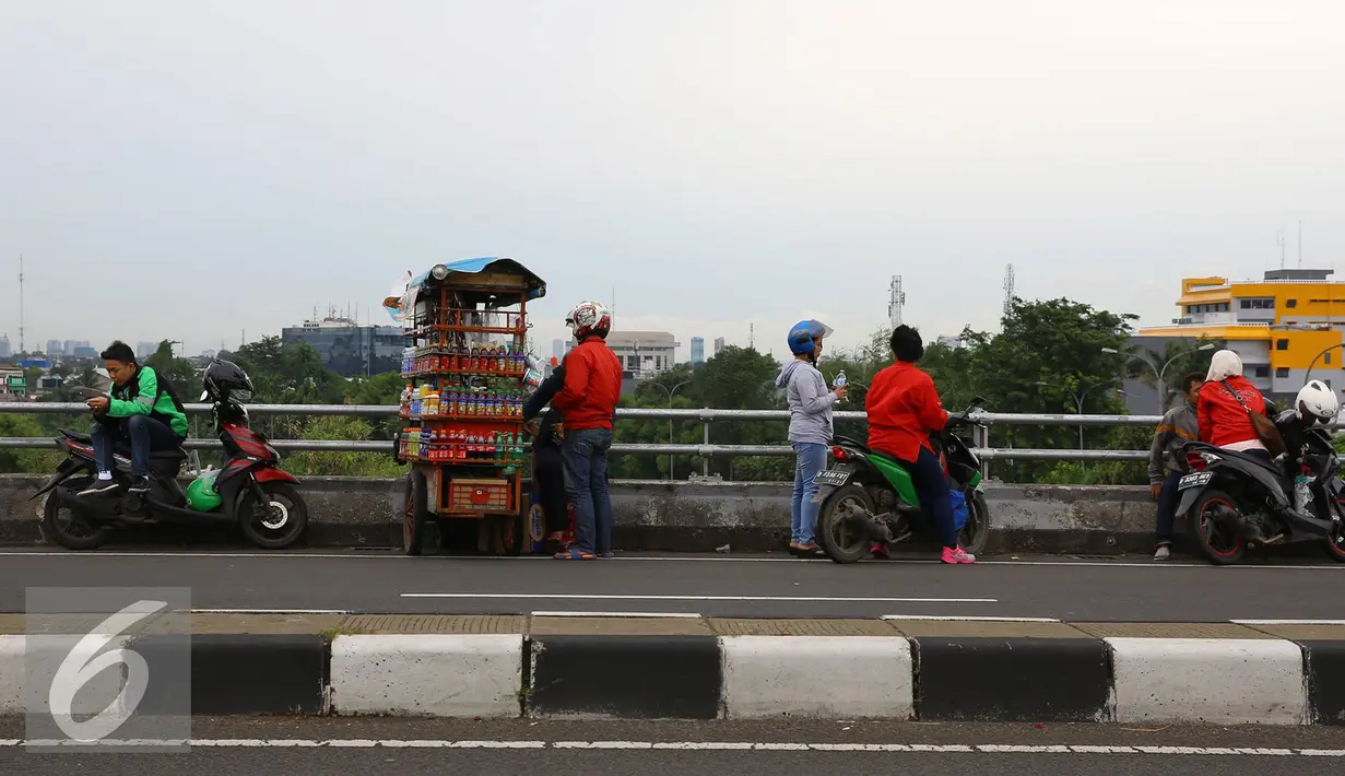 Pengendara sepeda motor menepikan kendaraannya di atas jalan layang Pasar Rebo, Jakarta, Sabtu (14/1). Setiap hari, jalan layang tersebut menjadi tempat untuk menghabiskan waktu bagi warga sekitar serta pemotor. (Liputan6.com/Immanuel Antonius)