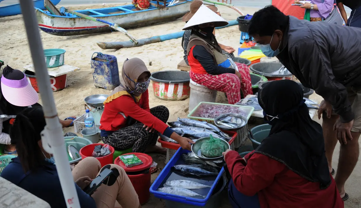 Pedagang ikan menjual hasil tangkapan di pasar tepi pantai saat Pemberlakuan Pembatasan Kegiatan Masyarakat (PPKM) Level 3 di Kedonganan, Kuta, Badung, Bali, Jumat (23/7/2021). Pandemi COVID-19 menyebabkan penurunan terbesar yang pernah dialami industri pariwisata Bali. (SONY TUMBELAKA/AFP)