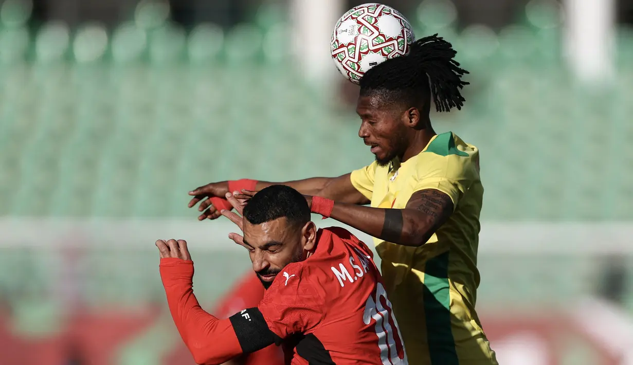 Pemain Mesir, Mohamed Salah (kiri) berduel udara dengan pemain Benin, Imourane Hassane dalam laga 16 besar Piala Afrika 2025 di Grand Stadium, Agadir, Maroko, Senin (05/01/2026) waktu setempat. (AFP/Franck Fife)
