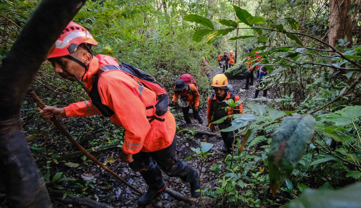 Dalam proses evakuasi, Basarnas menyiapkan sekitar 400 hingga 500 personel gabungan untuk kelancaran operasi. Tampak dalam foto, tim gabungan pencarian dan penyelamatan mendaki menuju lokasi yang diduga sebagai tempat jatuhnya pesawat turboprop Indonesia Air Transport yang kehilangan kontak sehari sebelumnya saat terbang dari Yogyakarta ke Makassar, di Pegunungan Bulusaraung, Sulawesi Selatan, Minggu 18 Januari 2026. (Muchtamir/AFP)