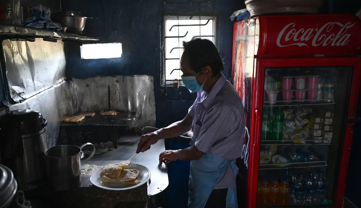 Penjual menyiapkan makanan di tokonya setelah pemadaman listrik di Kolombo, Rabu (2/3/2022). Sri Lanka mengumumkan pemadaman listrik setiap hari selama 7,5 jam, terlama dalam lebih dari seperempat abad, karena krisis valuta asing membuatnya tidak dapat mengimpor minyak. (Ishara S. KODIKARA/AFP)