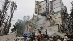 Tim penyelamat membersihkan puing-puing saat bekerja di lokasi bangunan tempat tinggal yang hancur akibat serangan udara Rusia di Kyiv pada 31 Juli 2025. (Tetiana DZHAFAROVA/AFP)