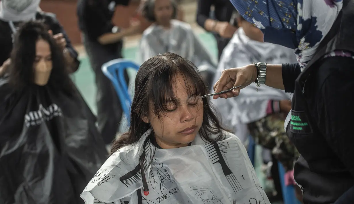 Warga saat potong rambut gratis di Masjid Muhammad Cheng Hoo, Surabaya, Jawa Timur, Senin (18/4/2022). Kegiatan berbagi dalam bulan Ramadhan yang digelar Baksose Suroboyo dan Ngaji Komunitas Salon (Ngasal) Surabaya itu diikuti sekitar 450 orang. (AFP/Juni Kriswanto)