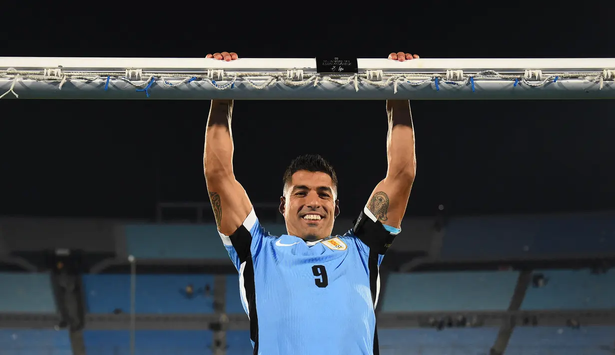 Pemain Uruguay, Luis Suarez bergantungan di mistar gawang saat foto bersama dalam acara perpisahannya dengan Timnas Uruguay sebelum laga kualifikasi Piala Dunia 2026 melawan Paraguay yang berlangsung di Stadion Centenario, Montevideo, Uruguay, Sabtu (07/09/2024) WIB. (AFP/Dante Fernandez)