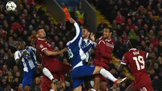Bek Liverpool, Virgil van Dijk (kedua kanan) menyundul ke arah gawang FC Porto pada leg kedua babak 16 besar Liga Champions di Stadion Anfield, Selasa (6/3). Liverpool sukses melaju ke perempat final dengan bermain imbang tanpa gol. (PAUL ELLIS/AFP)