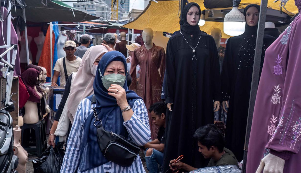 Pemerintah melalui Menteri Keuangan (Menkeu) Purbaya Yudhi Sadewa mengambil langkah tegas untuk menyetop impor pakaian bekas. Tampak dalam foto, pembeli berjalan di antara kios-kios penjual pakaian lokal di salah satu pasar tradisional, Jakarta, Kamis 20 November 2025. (BAY ISMOYO/AFP)