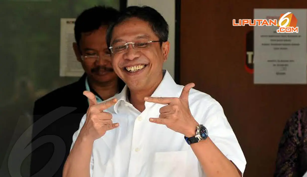 Ahmad Fathanah memberikan salam metal ke arah media usai mencoblos di TPS   yang didirikan di Gedung KPK, Kuningan, Jakarta (Liputan6.com/Johan Tallo)