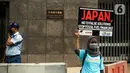 Seorang wanita yang tergabung dalam Walhi DKI menggelar aksi di depan Kedutaan Besar Jepang, Jakarta, Rabu (3/8/2022). Aksi simbolik tersebut bertepatan dengan pertemuan Japan Energy Summit di Tokyo yang masih memberikan solusi palsu mengatasi perubahan iklim. (Liputan6.com/Faizal Fanani)