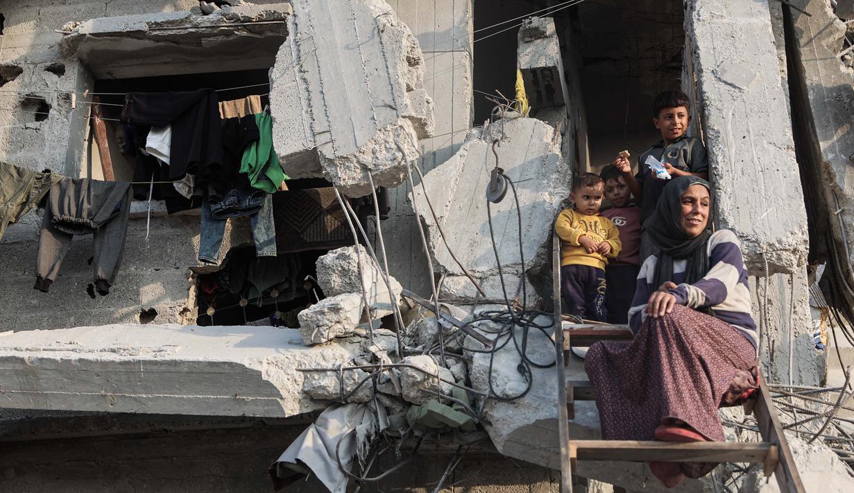 Bantuan ini merupakan bagian dari rencana tanggap darurat 60 hari di tengah meningkatnya serangan militer Israel di wilayah tersebut. Tampak dalam foto, sebuah keluarga Palestina memandang ke bawah dari rumah mereka yang rusak parah di Jabalia, di bagian utara Jalur Gaza, pada Jumat 7 November 2025. (Omar AL-QATTAA/AFP)