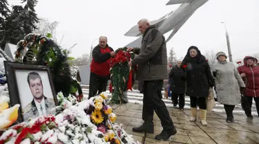 Warga meletakkan karangan bunga di dekat potret pilot asal Rusia, Oleg Peshkov di Lipetsk, Rusia, Rabu (2/12). Oleg Peshkov adalah pilot yang tewas saat pesawat tempur Su-24 yang dikemudikannya ditembak jatuh Turki pekan lalu. (REUTERS/Maxim Zmeyev)