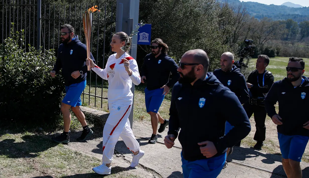 Juara menembak Olimpiade asal Yunani, Anna Korakaki memegang obor saat upacara penyalaan api Olimpiade Tokyo 2020 di Kota Tua Olympia, Yanani, Kamis (12/3/2020). (AP Photo/Thanassis Stavrakis)