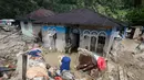 Selain korban jiwa, jumlah pengungsi juga terus meningkat. Tampak dalam foto, warga membersihkan rumah mereka dari lumpur di sebuah desa yang terdampak banjir bandang di Batang Toru, Sumatera Utara, Senin, 1 Desember 2025. (AP Photo/Binsar Bakkara)