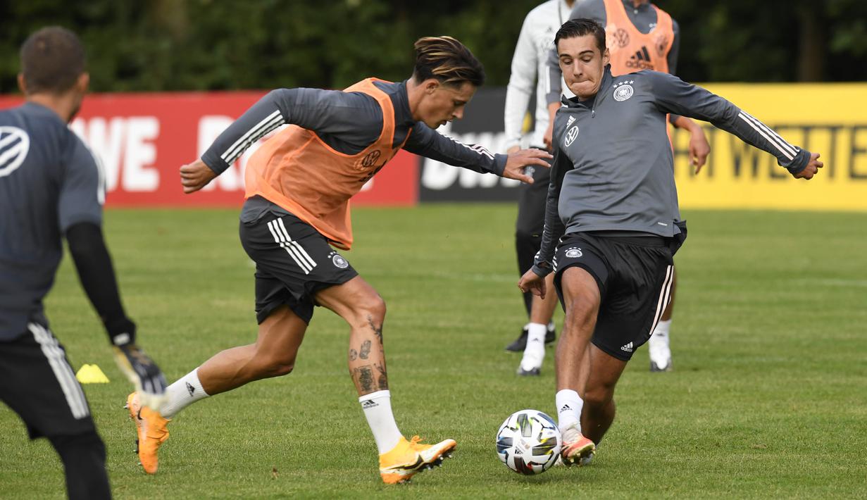 Pemain Timnas Jerman, Robin koch dan Florian Neuhaus, berebut bola saat sesi latihan jelang laga UEFA Nations League di Stuttgart, Senin (31/8/2020). Jerman akan berhadapan dengan Spanyol. (AFP/Thomas Kienzle)