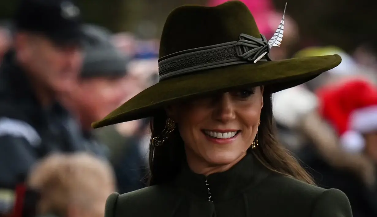 Kate Middleton, Princess of Wales dari Inggris tersenyum saat tiba untuk kebaktian Natal di Sandringham, Norfolk, Inggris pada 25 Desember 2022. Ibu tiga anak ini tampak bergaya dalam balutan coat hijau olive panjang yang bagian bawahnya lebar dari koleksi Alexander McQueen. (AFP/Daniel Leal)