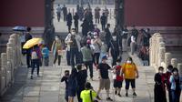 Para pengunjung mengenakan masker saat mengunjungi Kota Terlarang, Beijing, China, Jumat (1/5/2020). Kota Terlarang kembali dibuka setelah ditutup lebih dari tiga bulan karena pandemi virus corona COVID-19. (AP Photo/Mark Schiefelbein)