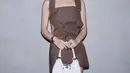Somi hadir di Fashion Show Prada, ia tampil dengan mini dress sleeveless cokelatnya dengan membawa kini bag putih. @prada