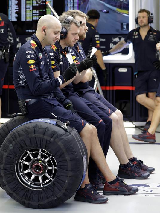 Tim mekanik Red Bull bersatai menikmati minuman usai sesi latihan bebas F1 GP Singapura di Marina Bay City Circuit, (15/9/2017). (AP/Wong Maye-E)