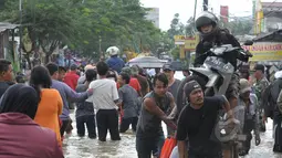 Pengendara sepeda motor memilih menggunakan gerobak untuk melewati banjir di kawasan Jalan KH Hasyim Ashari, Ciledug, Kota Tangerang, Selasa (10/2/2015). (Liputan6.com/Andrian M Tunay)