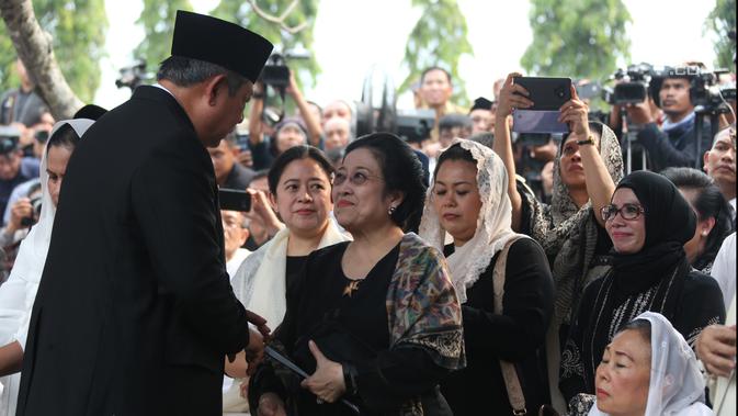 Presiden ke-6 RI Susilo Bambang Yudhoyono bersalaman dengan Presiden ke-5 RI Megawati Soekarnoputri usai prosesi pemakaman Ani Yudhoyono di TMP Kalibata, Jakarta, Minggu (2/6/2019). Megawati duduk bersebelahan dengan Ibu Negara Iriana Joko Widodo dan Sinta Nuriyah Wahid. (Liputan6.com/HO/Rangga)