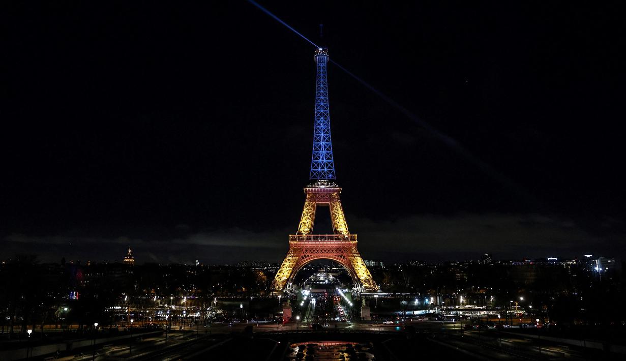 Foto ini menunjukkan Menara Eiffel yang diterangi dengan warna bendera Ukraina untuk menandai ulang tahun ketiga invasi Rusia ke Ukraina, di Paris, pada 24 Februari 2025. (Behrouz MEHRI/AFP)