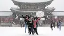 Pengunjung berswafoto di tengah salju di Istana Gyeongbok, istana kerajaan utama selama Dinasti Joseon dan salah satu landmark terkenal Korea Selatan di Seoul, Korea Selatan, 15 Desember 2022. (AP Photo/Ahn Young-joon)