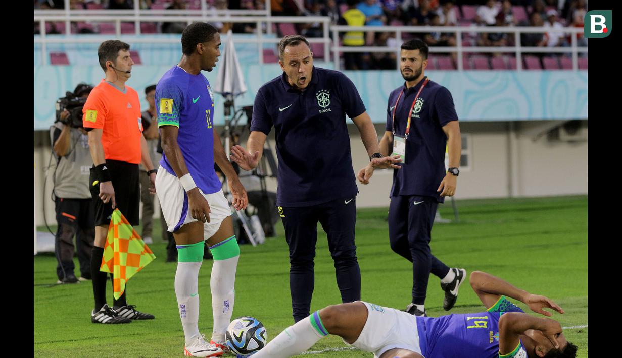 <p>Pelatih Timnas Brasil U-17, Phelipe Leal (tengah) berusaha menenangkan pemainnya setelah terjadi keributan dengan para pemain Ekuador U-17 dalam pertandingan babak 16 Besar Piala Dunia U-17 di Stadion Manahan, Solo, Senin (20/11/2023). (Bola.com/Arief Bagus)</p>