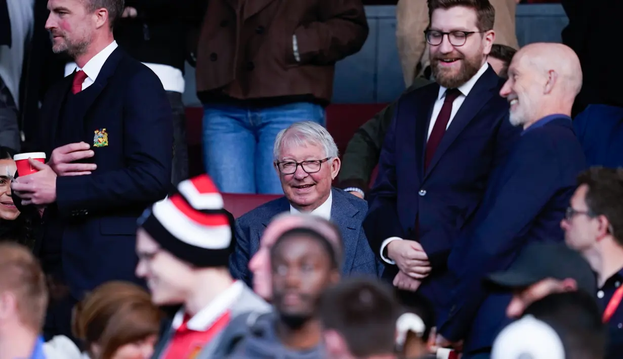 Pelatih legendaris Setan Merah, Sir Alex Ferguson, tampak tersenyum melihat Manchester United sukses melaju ke final Liga Europa 2024/2025 usai mengandaskan Athletic Bilbao dalam laga leg kedua semifinal yang dihelat di Old Trafford, Jumat (9/5/2025) dini hari WIB. (AP Photo/Dave Thompson)