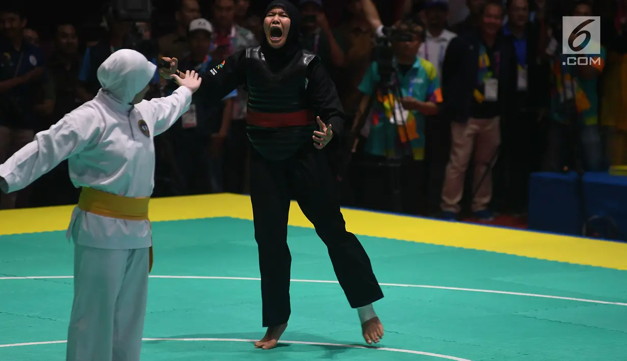 Pesilat Indonesia Pipiet Kamelia berselebrasi usai mengalahkan Thi Cam Nhi Nguyen dari Vietnam pada final nomor 60-65 kg putri pencak silat Asian Games 2018 di Padepokan Pencak Silat TMII, Jakarta, Rabu (29/8). (Merdeka.com/Imam Buhori)