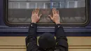 Aleksander (41) menempelkan tangan ke jendela saat mengucapkan selamat tinggal kepada putrinya Anna (5) di kereta api ke Lviv di Stasiun Kiev, Ukraina, 4 Maret 2022. Aleksander tinggal untuk berperang, sementara keluarganya meninggalkan Ukraina untuk mencari perlindungan. (AP Photo/Emilio Morenatti)