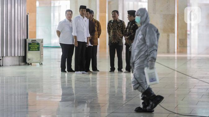 Presiden Joko Widodo atau Jokowi menyaksikan petugas menyemprotkan cairan disinfektan di Masjid Istiqlal, Jakarta, Jumat (13/3/2020). Proses sterilisasi ini dilakukan dalam rangka mencegah penularan virus corona Covid-19. (Liputan6.com/Faizal Fanani)