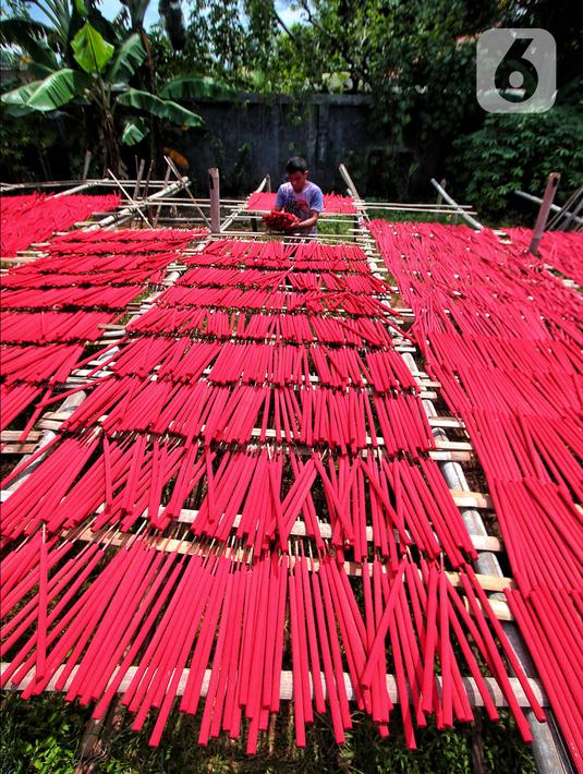 Seorang pekerja menjemur hio dupa di sentra industri kecil pembuatan hio di Tangerang, Banten, Senin (9/1/2023). Jelang perayaan Imlek, pesanan hio dupa mengalami peningkatan untuk kebutuhan sembahyang. (Liputan6.com/Angga Yuniar)