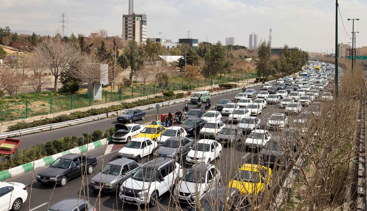 Banyak warga Iran mulai meninggalkan kota untuk mencari keselamatan. Tampak dalam foto, para pengendara mobil melintas di sebuah jalan di Teheran, Iran pada Sabtu 28 Februari 2026. (Atta KENARE/AFP)