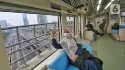 Masyarakat menikmati perjalanan saat mengikuti uji coba operasional terbatas LRT Jabodebek, Jakarta, Minggu (27/08/2023). (Liputan6.com/Angga Yuniar)