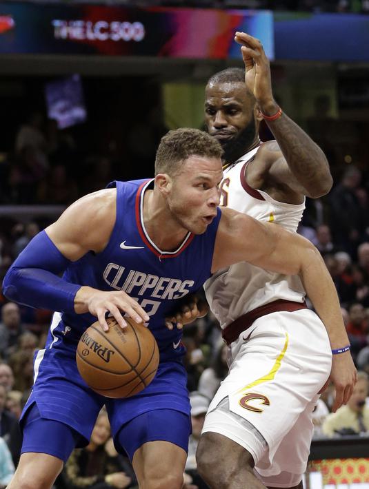 Pemain Los Angeles Clippers, Blake Griffin (kiri) berusaha melewati adangan pemain Cavaliers, LeBron James pada laga NBA basketball game di Quicken Loans Arena, Cleveland, (18/11/2017), Cavs menang 118-113. (AP/Tony Dejak)