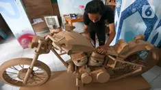 Perajin menyelesaikan pembuatan motor dari kardus di Workshop Bumi Kardus, Depok, Jawa Barat, Jumat (15/7/2022). Kerajinan berbahan baku kardus tersebut dijual dengan harga Rp 400 ribu hingga Rp 60 juta tergantung tingkat kesulitan dan ukuran. (Liputan6.com/Herman Zakharia)