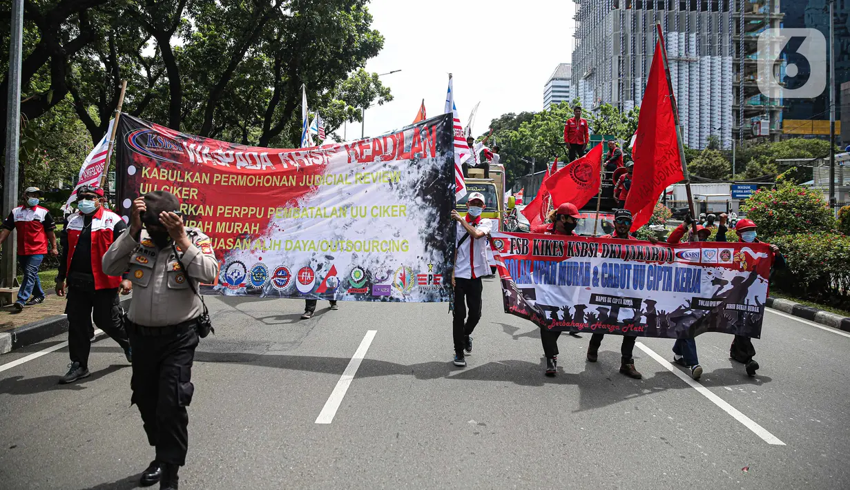 Massa buruh gabungan berjalan kaki saat menggelar aksi di kawasan Patung Arjuna Wijaya, Jakarta, Kamis (25/11/2021). Dalam aksinya, ratusan buruh tersebut menuntut pembatalan Omnibus Law Undang-Undang Cipta Kerja dan kenaikan upah 2022. (Liputan6.com/Faizal Fanani)