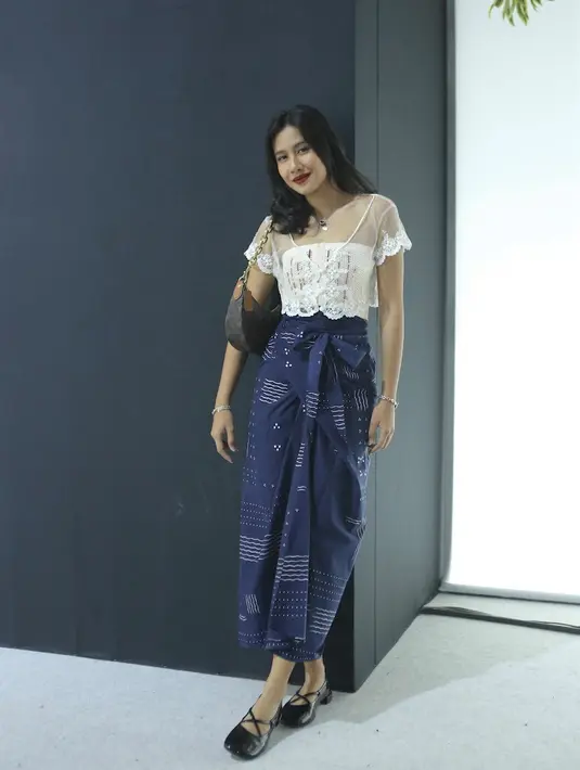 Shenina Cinnamon juga hadir dengan atasan crop top transparan dan kemben putihnya. Dipadukan kain lilit bermotif dari Sejauh Mata Memandang serta ballet shoes hitamnya. [Daniel Kampua]