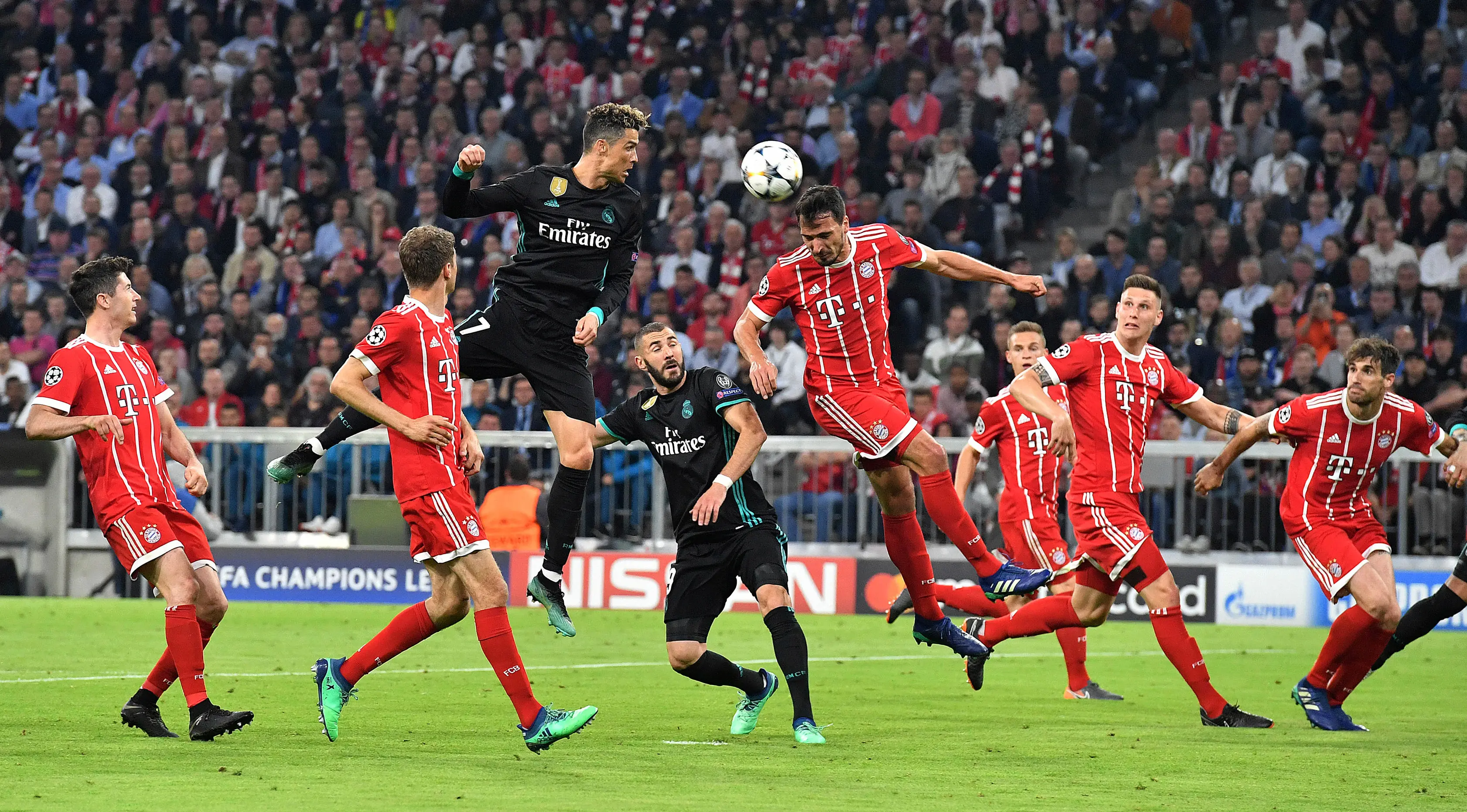 Megabintang Real Madrid, Cristiano Ronaldo menyundul bola dibayangi pemain Bayern Munchen pada leg pertama semifinal Liga Champions di Allianz Arena, Rabu (25/4) (AP/Kerstin Joensson)