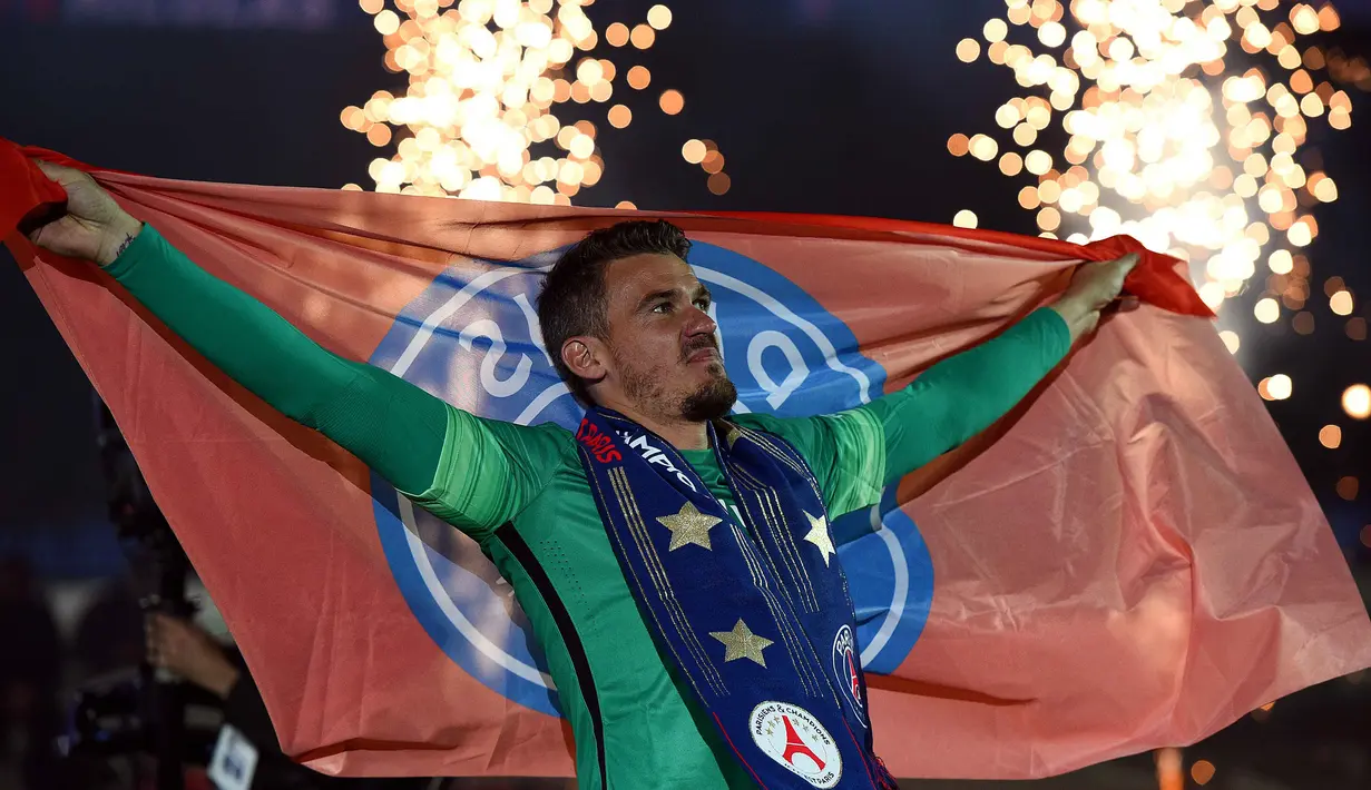 Kiper Paris Saint-Germain, Nicolas Douchez membentangkan bendera PSG saat perayaan perayaan juara liga prancis di Stadion Parc des Princes stadium, Paris,(14/5/2016).  (AFP/Franck Fife)