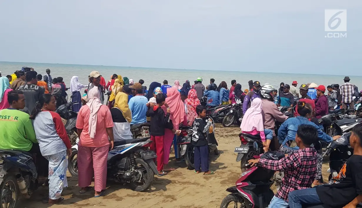 Warga berkerumun menantikan evakuasi pesawat Lion Air JT 610 di Pantai Pakis Jaya, Karawang, Jawa Barat, Senin (29/10). Lion Air JT 610 hilang kontak usai lepas landas dari Bandara Soetta saat menuju Pangkalpinang. (Liputan6.com/Herman Zakharia)