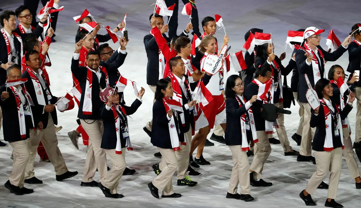 Kontingen Indonesia mengibarkan bendera Merah Putih ketika mengikuti devile pembukaan SEA Games XXIX di Stadion Bukit Jalil, Kuala Lumpur, Sabtu (19/8). Bendera Indonesia dicetak terbalik dalam buku panduan SEA Games 2017. (AP Photo/Vincent Thian)