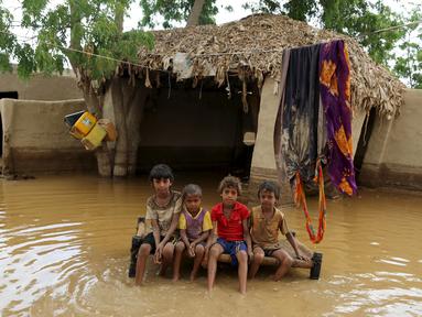 Sejumlah Anak duduk di tempat tidur di depan sebuah rumah yang dilanda banjir setelah hujan lebat di sebuah desa di provinsi Laut Merah Yaman, Houdieda, Jumat, 15 April 2016. (REUTERS/Abdul Jabbar Zeyad)