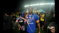 Pemain Belakang Arema Cronus, Victor Igbonefo berjalan sambil memegang piala usai mengalahkan Sriwijaya FC di final SCM Cup 2015 di Stadion Jakabaring,Selasa (27/1/2015). Arema Cronus unggul 1-0 atas Sriwijaya FC. (Liputan6.com/Johan Tallo)